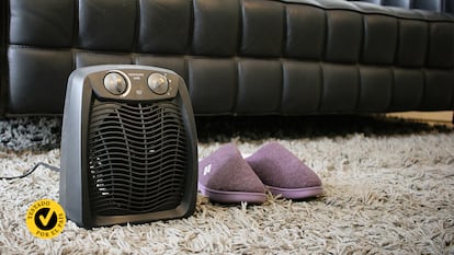 Un calefactor portátil con unas zapatillas en el salón de una casa.