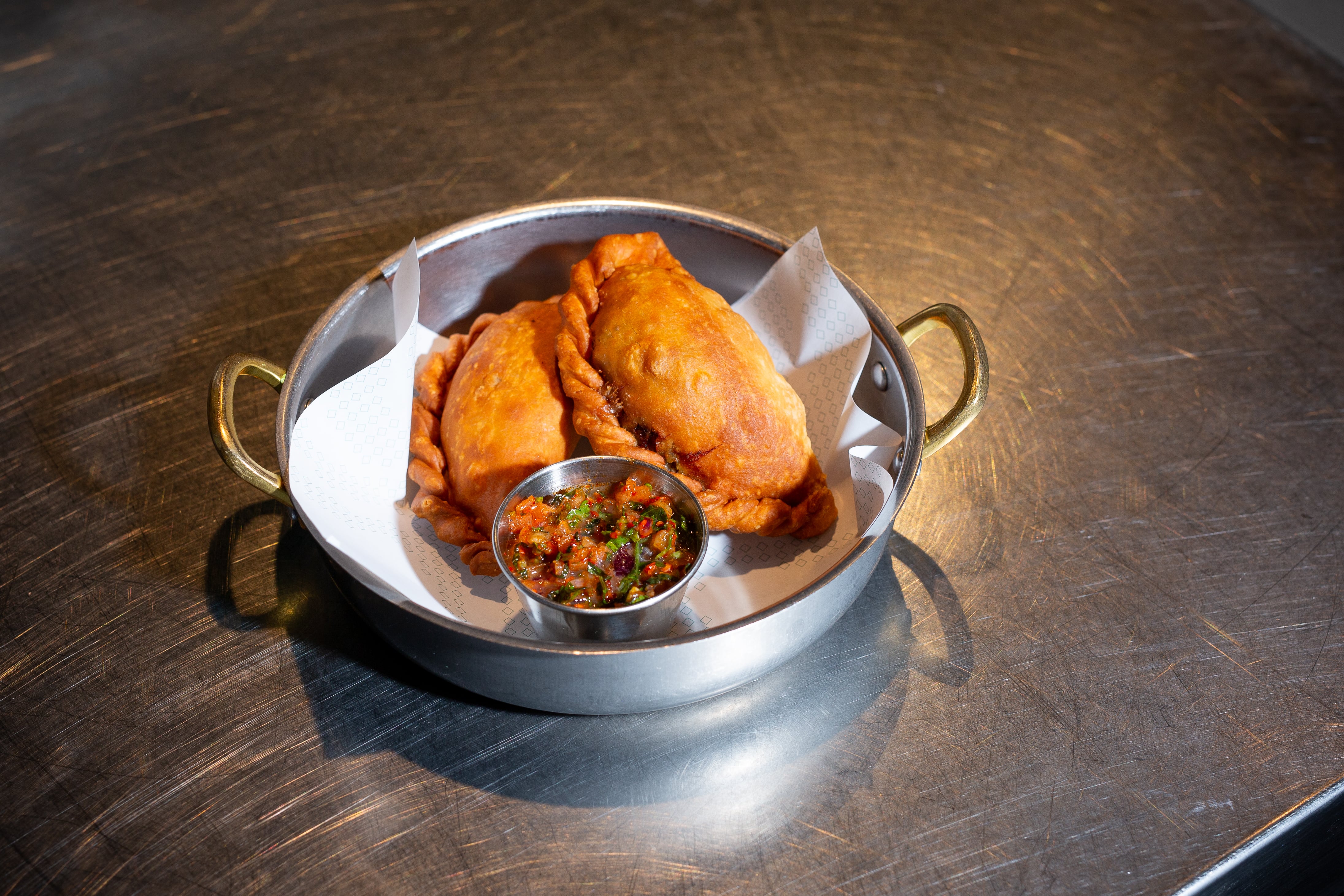 Empanada de birria mexicana elaborada con rabo de toro de Insurgente, en su puesto del Mercado de Chamberí.