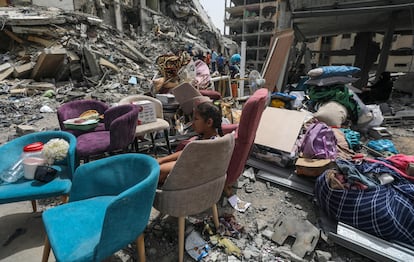 Una niña  permanece sentada entre los muebles rescatados de los escombros de una casa en Al Nuseirat, después de regresar a su barrio tras la retirada del ejército israelí, el 18 de abril de 2024.