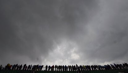 Aficionados siguen el torneo bajo un cielo nublado.