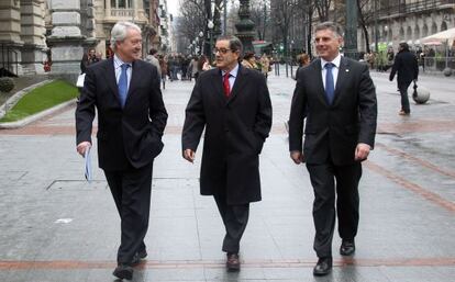 Mario Fernández camina por la Gran Vía bilbaína entre los presidentes de la Vital, Carlos Zapatero (izquierda), y la Kutxa, Xabier Iturbe.