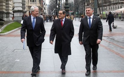 Mario Fernández camina por la Gran Vía bilbaína entre los presidentes de la Vital, Carlos Zapatero (izquierda), y la Kutxa, Xabier Iturbe.