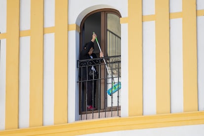 Una mujer trabaja en la limpeza de las ventanas en un hotel de Sevilla.