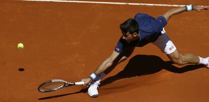 El tenista serbio Novak Djokovic, alarga el brazo para no perder la pelota.