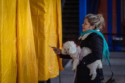 Una mujer acude a votar con su mascota. 