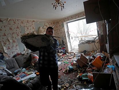Un hombre retira escombros de su vivienda tras un bombardeo en la ciudad de Yasinovataya, en la región de Donetsk. Esta madrugada, Vladímir Putin ha endurecido la ofensiva en el séptimo día de la invasión rusa con el lanzamiento de paracaidistas sobre Járkov, la segunda mayor ciudad de Ucrania, donde siguen los combates.
