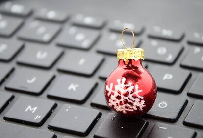 Una bola de Navidad encima de un teclado de ordenador.