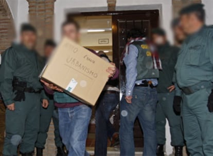 Agentes de la Guardia Civil sacan documentos de urbanismo del Ayuntamiento de Alcaucín (Málaga).