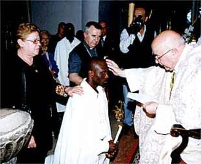 Bautizo de Joseph Locky (al fondo) y un compañero en la iglesia Nuestra Señora de África, en Ceuta, el Domingo de Resurreción. La mayoría de los nigerianos del CETI se han convertido al catolicismo.