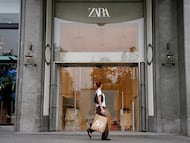 Una persona que lleva una bolsa pasa frente a una tienda de Zara. REUTERS