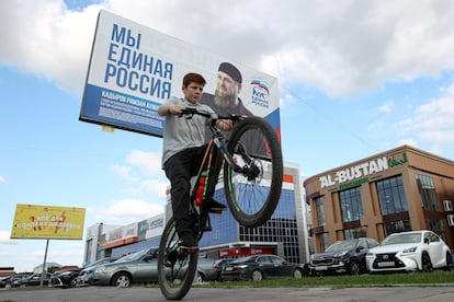 Un niño pasa en bicicleta ante un cartel electoral de Rusia Unida con un retrato de líder checheno Ramán Kadírov, este martes en Grozni.
