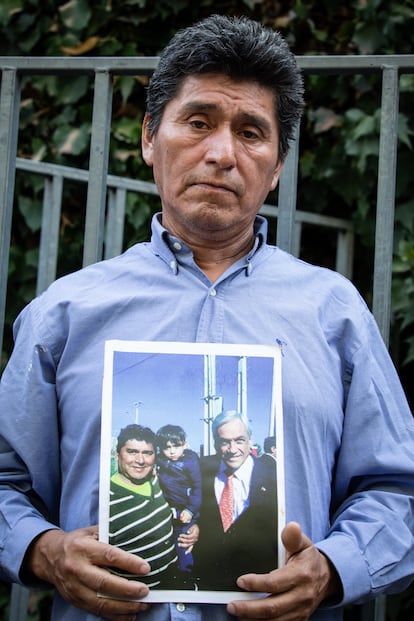 Un hombre sostiene una fotografía que se tomó hace años con el exmandatario, durante la velatón afuera de la casa de Piñera.