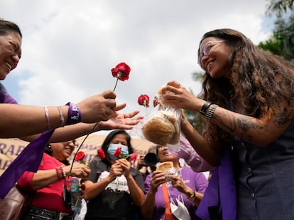 Mujeres intercambian rosas y pan durante una manifestación en Manila (Filipinas).