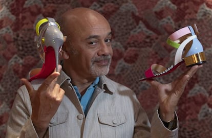 El dissenyador Christian Louboutin, amb dos dels seus dissenys a la botiga de Barcelona.