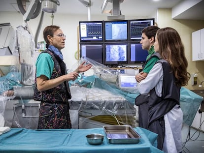 Dos alumnos de la Universidad de Valencia escuchan las explicaciones de un cardiólogo en el Hospital Clínico de Valencia.