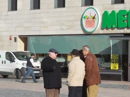 Varios clientes a la puerta de una tienda de Mercadona.