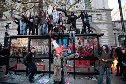 Un grupo de estudiantes, subidos a una parada de autobuses en Londres.