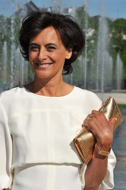 Ines de la Fressange muy favorecida de blanco con cartera dorada. 