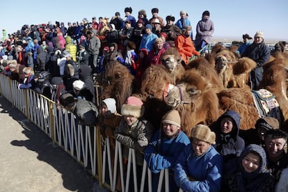 Aficionados se amontona para ver un desfile con trajes típicos.