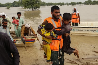 Los equipos de rescate ayudan a evacuar a personas afectadas por las inundaciones en el distrito de Rajanpur, Pakistán.