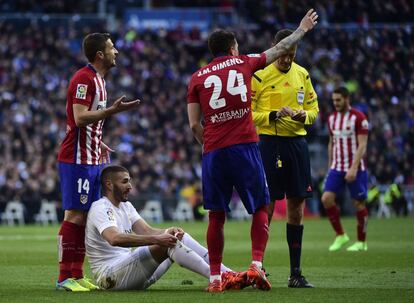 Los jugadores del Atlético de Madrid Gabi (i) y José María Giménez (d) protestan al árbirtro mientras Benzema, del Real Madrid, permanece en el suelo.