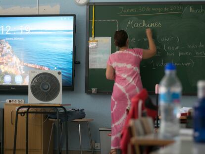 Una profesora de inglés de un colegio de Madrid se las arregla para dar clase este jueves, a 31 grados de temperatura, con un ventilador.