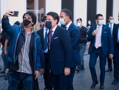 El primer ministro italiano Giuseppe Conte posa para una fotografía con un admirador.