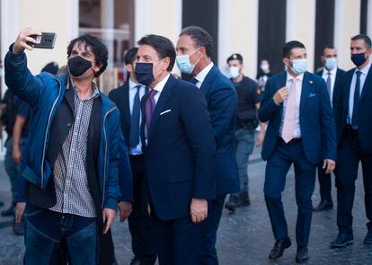 El primer ministro italiano Giuseppe Conte posa para una fotografía con un admirador.