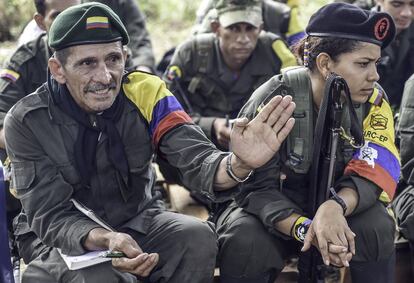 TO GO WITH AFP STORY by Hector Velasco
Cornelio (L), a member of the Revolutionary Armed Forces of Colombia (FARC), speaks during a "class" on the peace process between the Colombian government and their force, at a camp in the Colombian mountains on February 18, 2016. They still wear green combat fatigues and carry rifles and machetes, but now FARC rebel troops are sitting down in the jungle to receive "classes" on how life will be when they lay down their arms, if their leaders sign a peace deal in March as hoped.  AFP PHOTO / LUIS ACOSTA