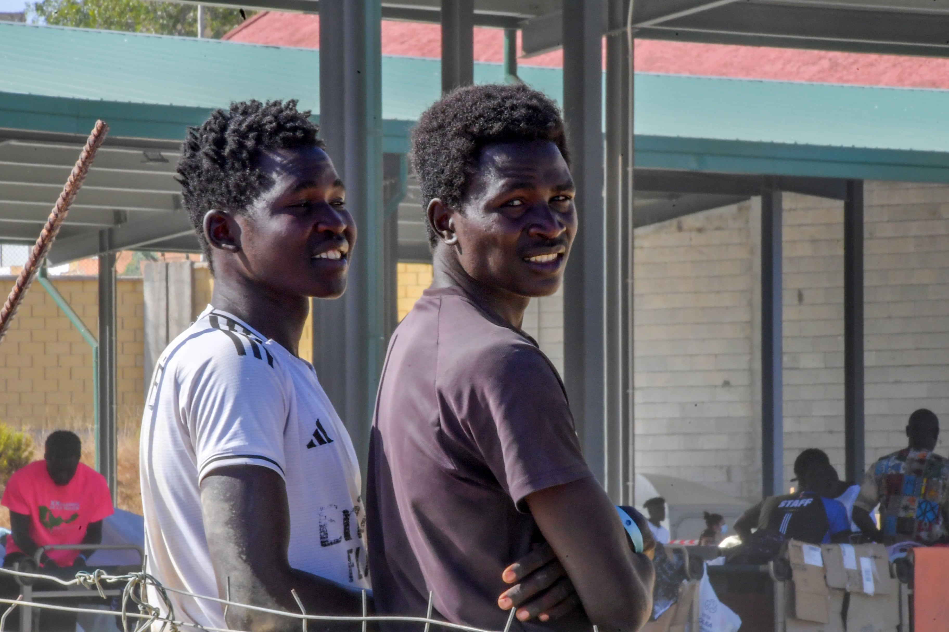 Dos chicos subsaharianos apoyados en el muro en Loma Margarita, Ceuta.