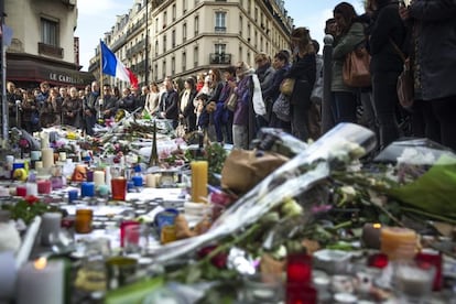 Numerosas personas guardan un minuto de silencio como homenaje a las víctimas de los atentados del viernes en la capital francesa ante el bar le Carillon de París, Francia.