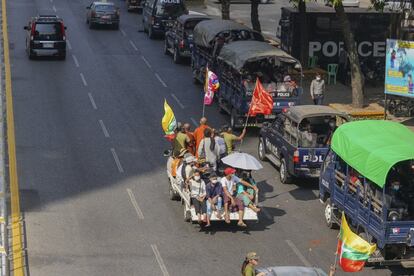 Un vehículo con simpatizantes del golpe de Estado pasa junto a una fila de camiones de la policía estacionados cerca de la comisaría de policía de Kyauktada, en Yangon. En un comunicado distribuido por las redes sociales, con el nombre pero no la firma de la consejera de Estado, Aung San Suu Kyi, la NLD ha condenado el golpe como un regreso a la dictadura y ha pedido a la población que “resista con firmeza” a la acción militar.