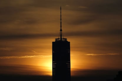 El sol tapa la torre One World Trade Center durante el amanecer visto desde el barrio de Heights , en Nueva York.