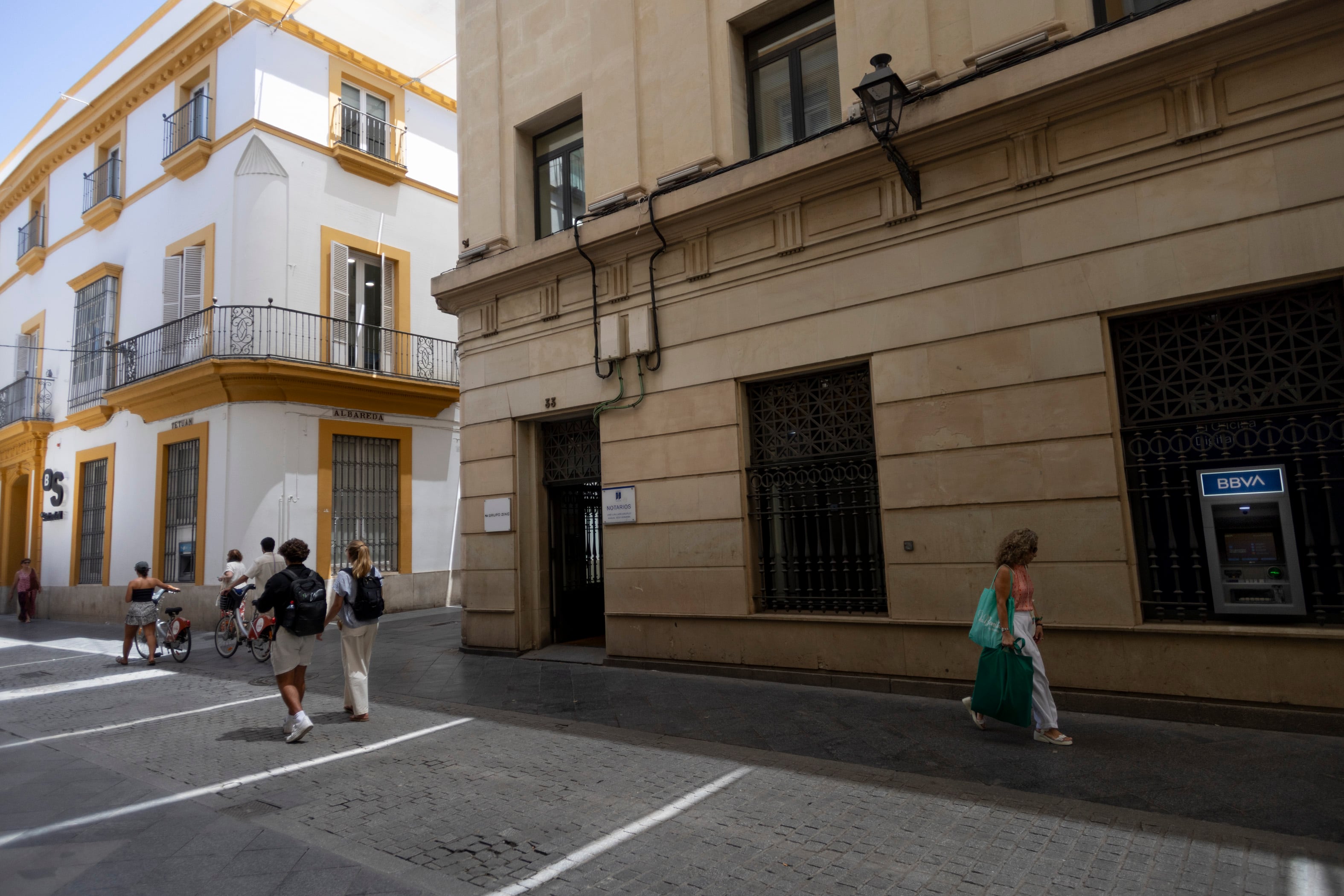 A la izquierda, una sucursal del Banco Sabadell; a la derecha, un cajero del BBVA, en la calle Tetuán de Sevilla.