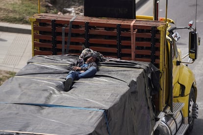 Una persona duerme encima de un camión atascado en un bloqueo al sur de Bogotá.