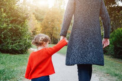Una madre caminando con su hija por el parque