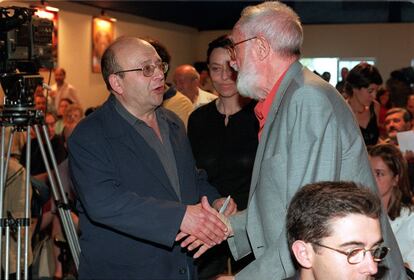 El escritor Manuel Vázquez Montalbán saluda a José Luis Sampedro, en Madrid.