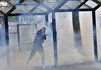 Un participante devuelve a la policia el gas lacrimógeno que le ha sido lanzado durante la manifestación en Nantes.