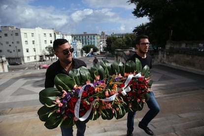Dos jóvenes cubanos con una corona de flores en honor a Fidel Castro, en la manifestación de la Universidad de La Habana, tras la muerte de este.