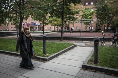 Una mujer pasea por uno de los parques que conectan los diversos bloques del gueto semicerrado de Mjølnerparken, en el centro de Copenhague, en el que viven casi 2.000 vecinos.