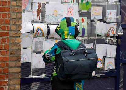 Un niño mira los dibujos de condolencias realizados por los compañeros de los alumnos del colegio de Sint Lambertus, Bélgica, muertos en un accidente de autobús en Suiza.
