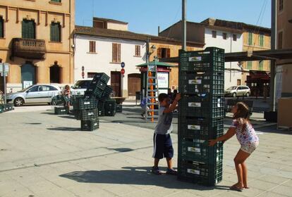 Un niño y una niña juegan con cajas de sandía en Campos, Mallorca, en agosto de 2014. / Arquitectives