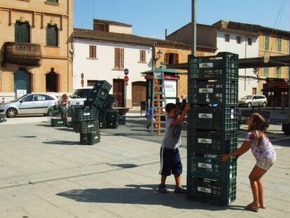 Un niño y una niña juegan con cajas de sandía en Campos, Mallorca, en agosto de 2014. / Arquitectives
