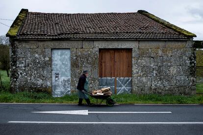 Una mujer transporta leña en San Cristovo de Cea (Ourense), en una imagen de archivo.