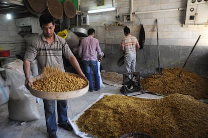 Un hombre trabaja los pistachos en una pequeña fábrica en Teherán, Irán. 