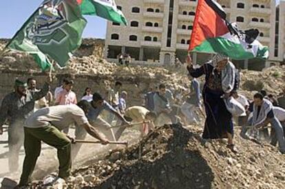 Varios palestinos trabajan en los restos de una casa atacada por Israel.