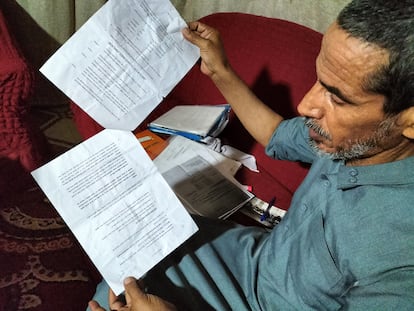 Riad El Shtiwi shows the documents of his petition as he sits on a sofa in his house in a Bedouin settlement near Tel Arad in Israel's Negev desert in June.