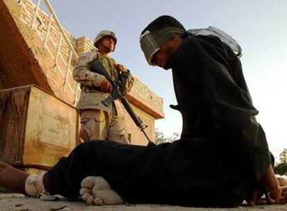 Un soldado estadounidense vigila a un detenido iraquí el 22 de octubre de 2003.
