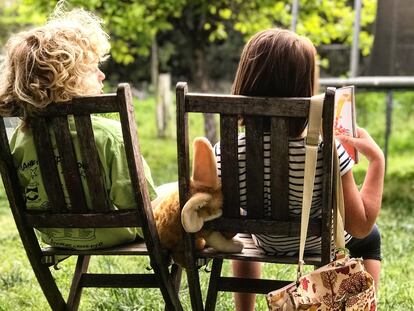 Dos niños conversan en el jardín.