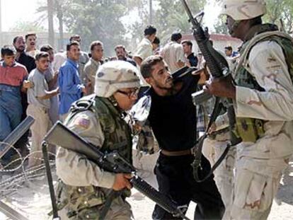 Dos soldados estodounidenses detienen a un antiguo miembro del Ejército iraquí en Bagdad.